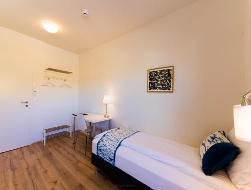 a bedroom with a bed and a desk in it at Salthús Guesthouse in Skagaströnd