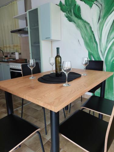 a table with wine glasses and a bottle on it at Apartman Marija II in Omišalj