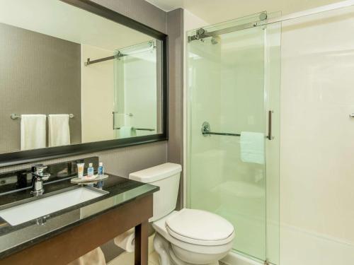 a bathroom with a toilet and a sink and a shower at Comfort Inn West in Ottawa