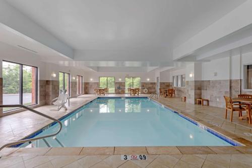 una gran piscina en una habitación con mesa y sillas en Comfort Suites Mt Juliet-Nashville Area, en Mount Juliet