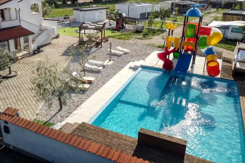 uma piscina com escorrega e um parque infantil em Luxury home Alpha, pool, camp Volme - nearby Kamenjak em Banjole