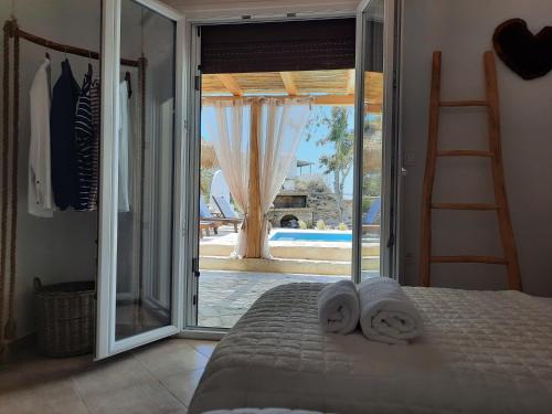 1 dormitorio con 1 cama y puerta corredera de cristal en Janakos View Apartment with Private Pool en Glinado Naxos