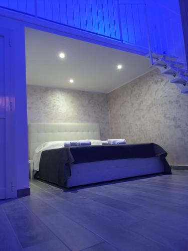 a bedroom with a bed in a room with blue lighting at La Perla di Ele in Bari