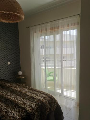 a bedroom with a bed and a large window at Ria´s Relax in Alvor