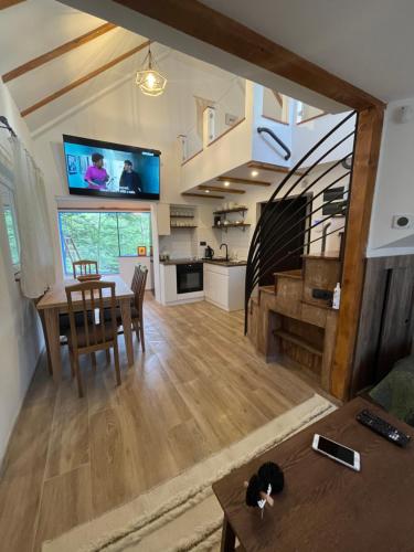een woonkamer en een keuken met een tafel en een televisie bij Forest House Divcibare in Divčibare