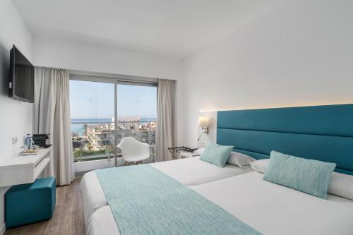 a hotel room with a large bed and a window at Alua Leo in Can Pastilla