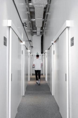 a person walking down a corridor in a hallway at Capsule Hotel Constellation 89 in Lviv