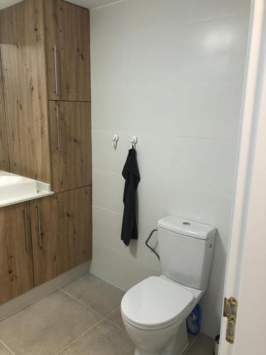 Łazienka z białą toaletą i drewnianą szafką w obiekcie Casa Monroe op Oasis Tamarindo 1 w Corralejo