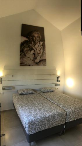 sypialnia z łóżkiem z obrazem na ścianie w obiekcie Casa Monroe op Oasis Tamarindo 1 w Corralejo