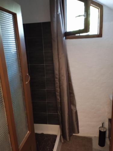 La salle de bains est pourvue d'un rideau de douche et d'une fenêtre. dans l'établissement Le Léna, à Largentière