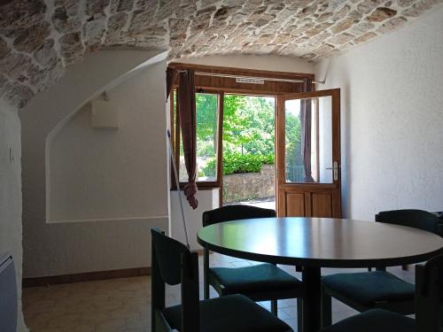 une salle à manger avec une table et des chaises et une fenêtre dans l'établissement Le Léna, à Largentière
