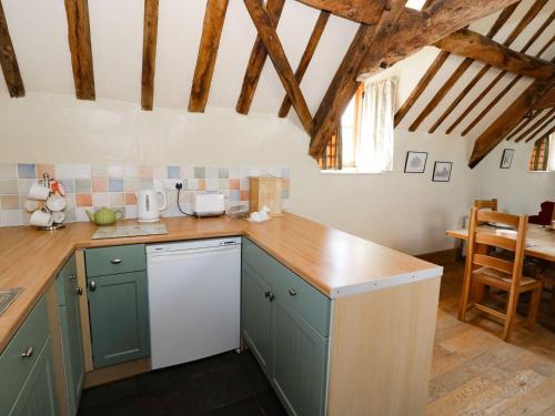 a kitchen with green cabinets and a wooden counter top at The Cider Loft in Ross on Wye
