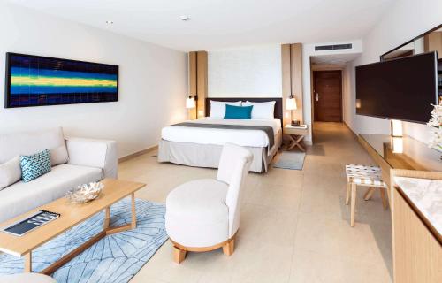 a hotel room with two beds and a television at Sonesta Ocean Point Resort- All Inclusive - Adults Only in Maho Reef