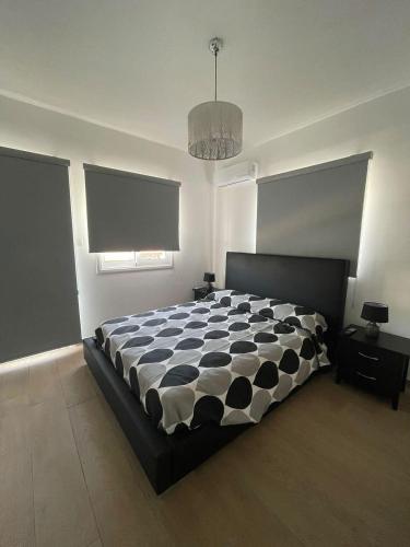 a bedroom with a bed with a black and white comforter at Oneiro Napa Suite in Ayia Napa