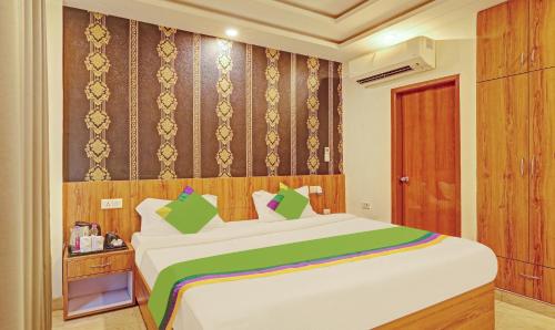 a bedroom with a large white bed with green pillows at Treebo Silver Stallion in Lucknow