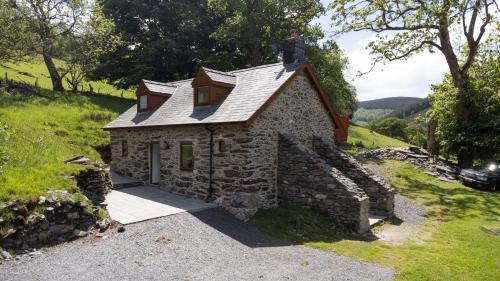 a man standing on the roof of a stone house at Snowdonia Holiday Cottage in Bala