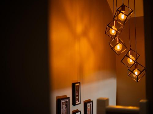 a group of lights hanging from a wall with pictures at Beckdale in Pickering