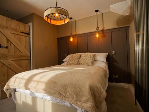 a bedroom with a large bed with a wooden door at Beckdale in Pickering