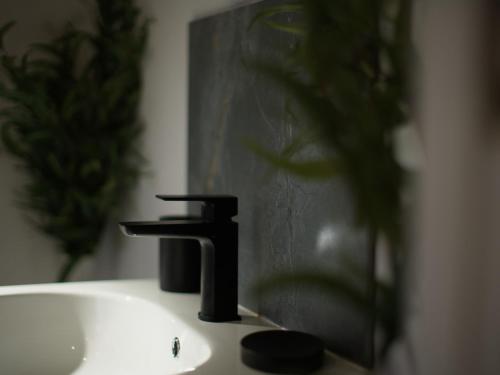 a bathroom sink with a black faucet on it at Beckdale in Pickering