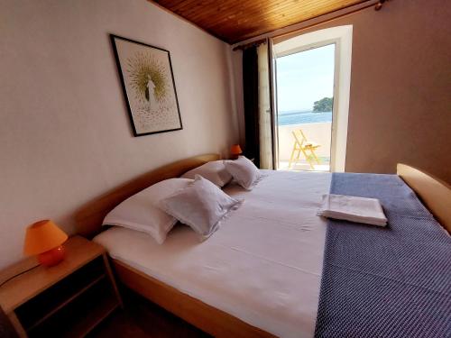 a bedroom with a bed with a view of the ocean at Apartman Darija in Preko