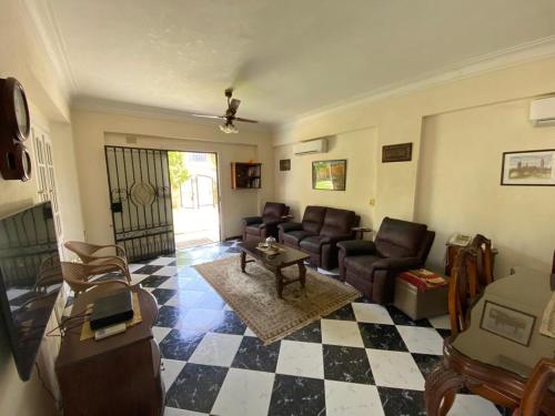 a living room with couches and a checkered floor at Paradise Villa - King Mariout in King Mariout