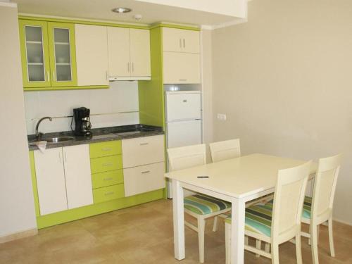 kuchnia ze stołem i krzesłami w pokoju w obiekcie Rocasol - Suites w mieście Calpe