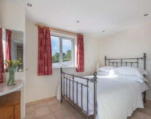a bedroom with a large bed and a window at Polmorla in Polzeath