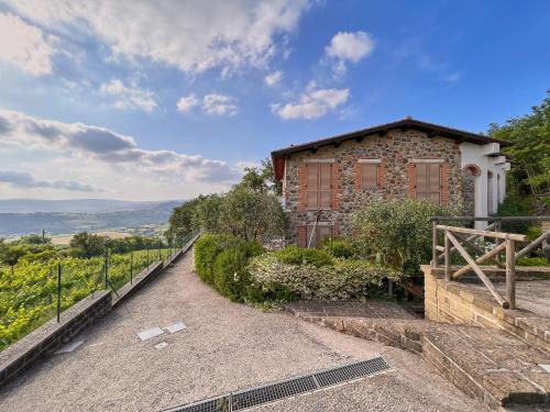 ein Backsteingebäude auf einem Hügel mit einem Zaun in der Unterkunft Villetta Oreste in Saturnia