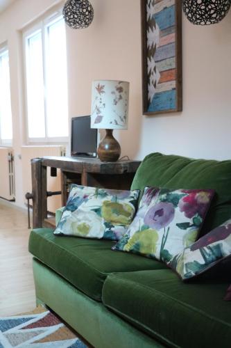 ein grünes Sofa im Wohnzimmer mit einem Tisch in der Unterkunft la maison du haut de Freydon Ambiance Scandinave in Allevard