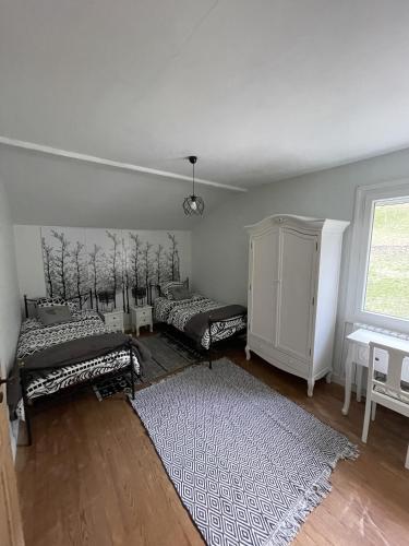 - un salon avec 2 lits et un tapis dans l'établissement la maison du haut de Freydon Ambiance Scandinave, à Allevard