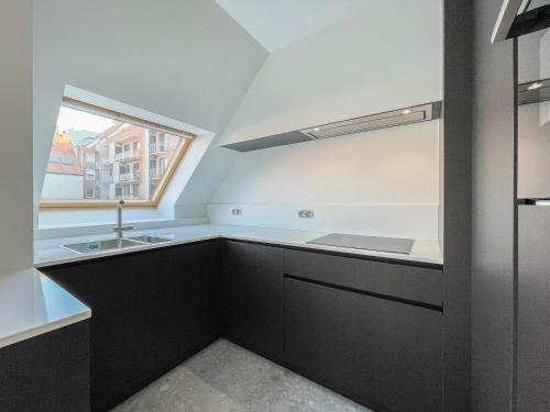 a kitchen with a sink and a window at Residentie Square - Nieuwbouw - 50 m van de zee in Knokke-Heist