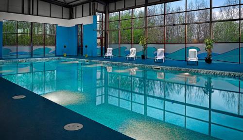 a large swimming pool with chairs in a building at Great National Hotel Ballina in Ballina