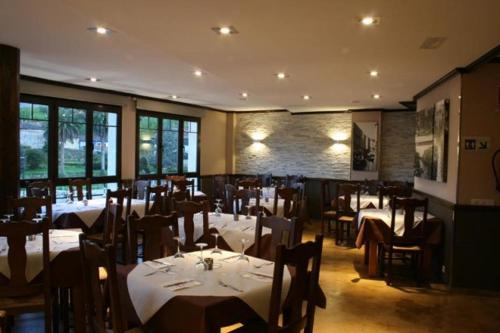 un ristorante con tavoli e sedie in una stanza di Apartamento Los Arcos a Llanes