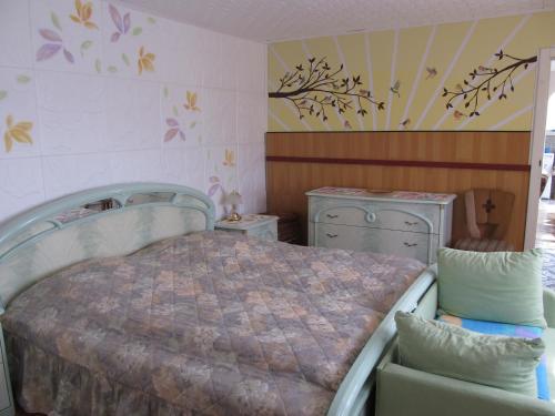 a bedroom with a bed and two dressers at zum Wiesengrund im Oderbruch in Altglietzen