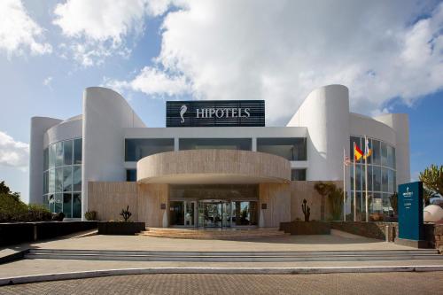 a large white building with a sign on it at Hipotels La Geria in Puerto del Carmen