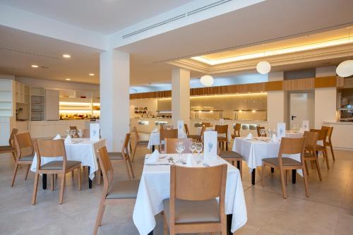 a dining room with white tables and chairs at Hipotels La Geria in Puerto del Carmen