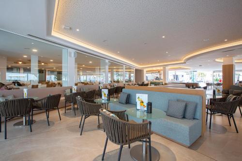 a restaurant with tables and chairs and a bar at Hipotels La Geria in Puerto del Carmen