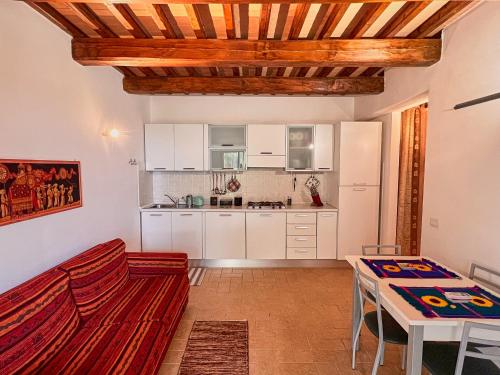 eine Küche mit weißen Schränken sowie einem Tisch und Stühlen in der Unterkunft Villetta Oreste in Saturnia