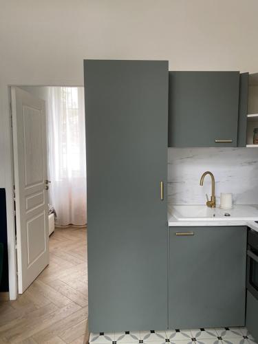 a kitchen with a sink and a counter top at La Suite Dandy - Beau T2 -Terrasse, Parking gratuit, Climatisation in Bagnères-de-Bigorre