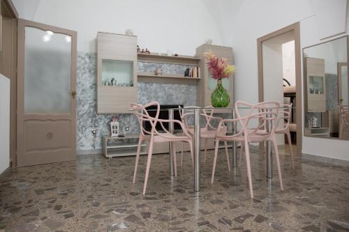 comedor con sillas rosas y mesa en Maison Montpellier, en Ceglie Messapica