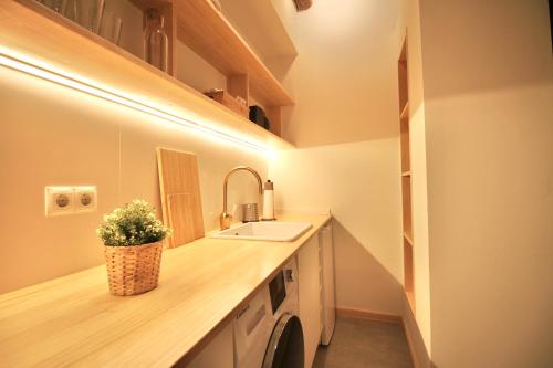 a bathroom with a sink and a washing machine at Fabrika Loft Serrallo in Tarragona