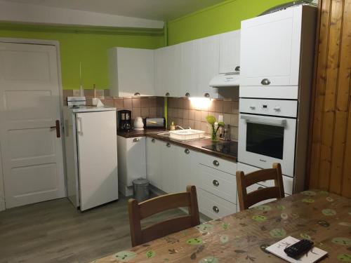 a kitchen with white appliances and a table with chairs at appartement à la montagne in Eaux-Bonnes
