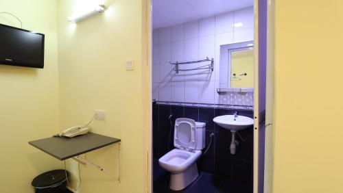 a small bathroom with a toilet and a sink at Hotel Seniman in Kuala Lumpur