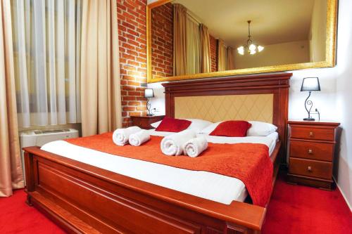 a bedroom with a large bed with towels on it at Hotel & Restoran Dvorac Gjalski in Zabok