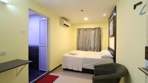 a small bedroom with a bed and a chair at Hotel Seniman in Kuala Lumpur