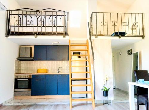 a loft kitchen with blue cabinets and a ladder at Apartment Madison in Cavtat