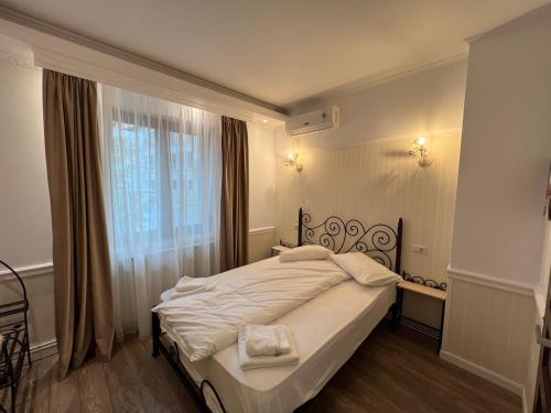 a bedroom with a white bed with a window at Hotel Boutique Cathedral Plaza Residences room for rent downtown in Bucharest