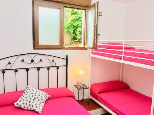 1 dormitorio con 2 literas y ventana en Apartamentos Casa Carmen, en Suances