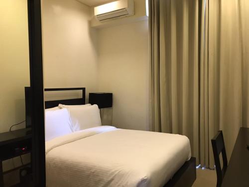 a bedroom with a white bed in a room at Sea Breeze Verandas at Anvaya Cove Penthouse Unit with Complete Sea View in Morong