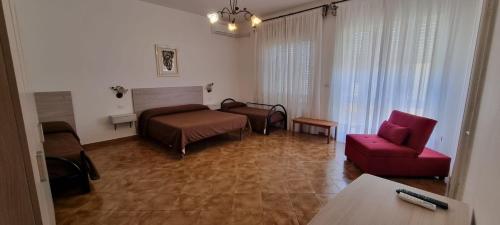 ein Wohnzimmer mit einem Bett und einem roten Sofa in der Unterkunft Controvento in Porto Cesareo